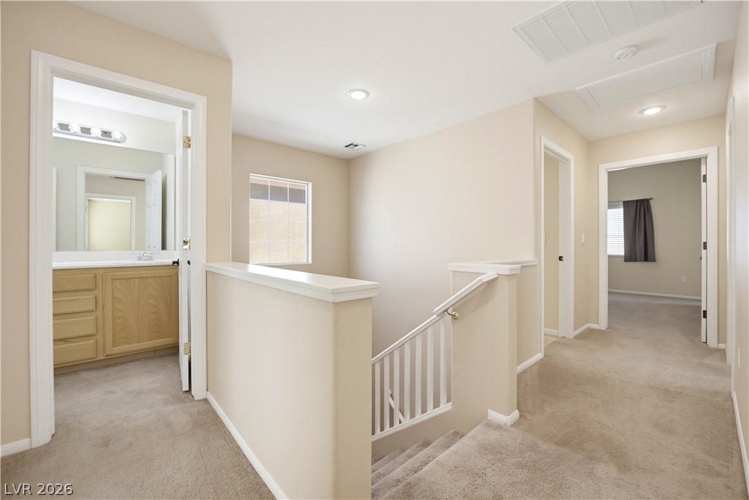 An open upper hallway coordinates carpeted floors and recessed lighting around a central staircase.