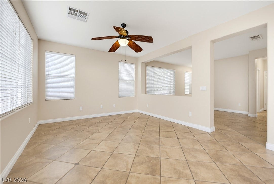 Durable tile flooring and generous window openings define this versatile open living space.
