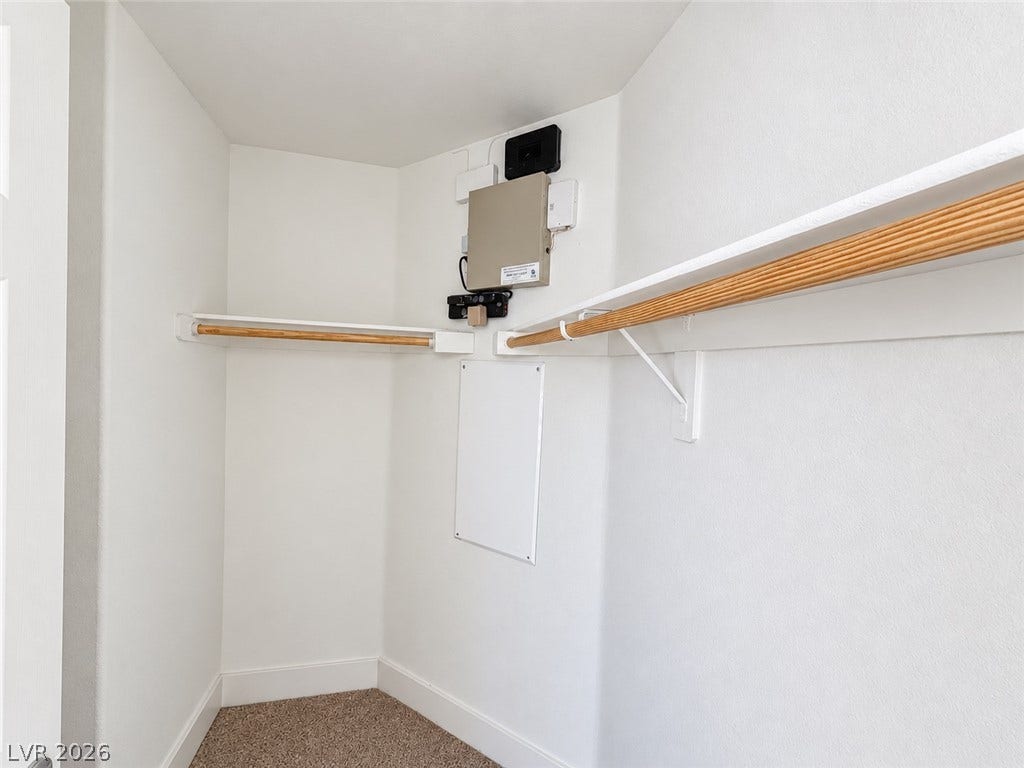 2321 Breckle Key Avenue, North Las Vegas, NV 89081 Functional hanging rods and built-in shelving maximize organization within this carpeted storage area.
