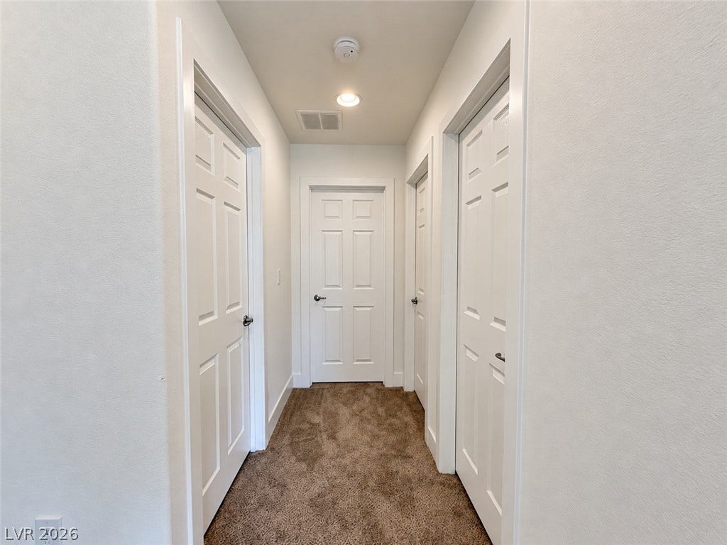 2321 Breckle Key Avenue, North Las Vegas, NV 89081 Plush carpeted hallway features multiple paneled doors and recessed ceiling lighting.
