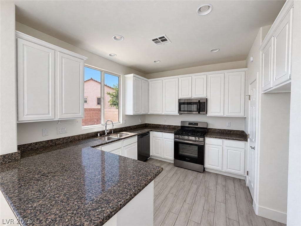 2321 Breckle Key Avenue, North Las Vegas, NV 89081 Polished granite countertops complement classic white cabinetry and modern stainless steel appliances.