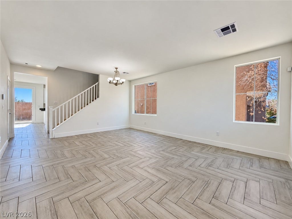 2321 Breckle Key Avenue, North Las Vegas, NV 89081 A spacious layout showcases modern herringbone pattern flooring and an elegant wooden staircase railing.