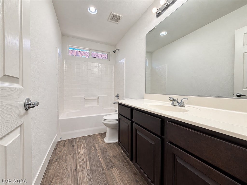 2321 Breckle Key Avenue, North Las Vegas, NV 89081 Wood-look flooring complements the dark vanity cabinet and clean tiled bath area.