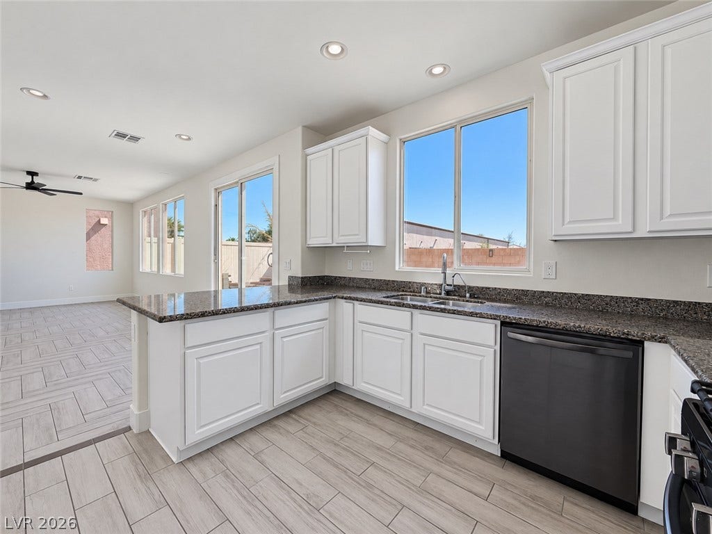 2321 Breckle Key Avenue, North Las Vegas, NV 89081 Gleaming stone countertops and crisp white cabinetry define this bright, open kitchen space.