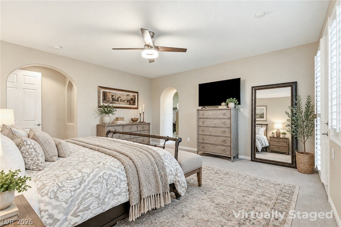 Smooth carpeting and arched doorways frame this comfortable primary bedroom retreat.