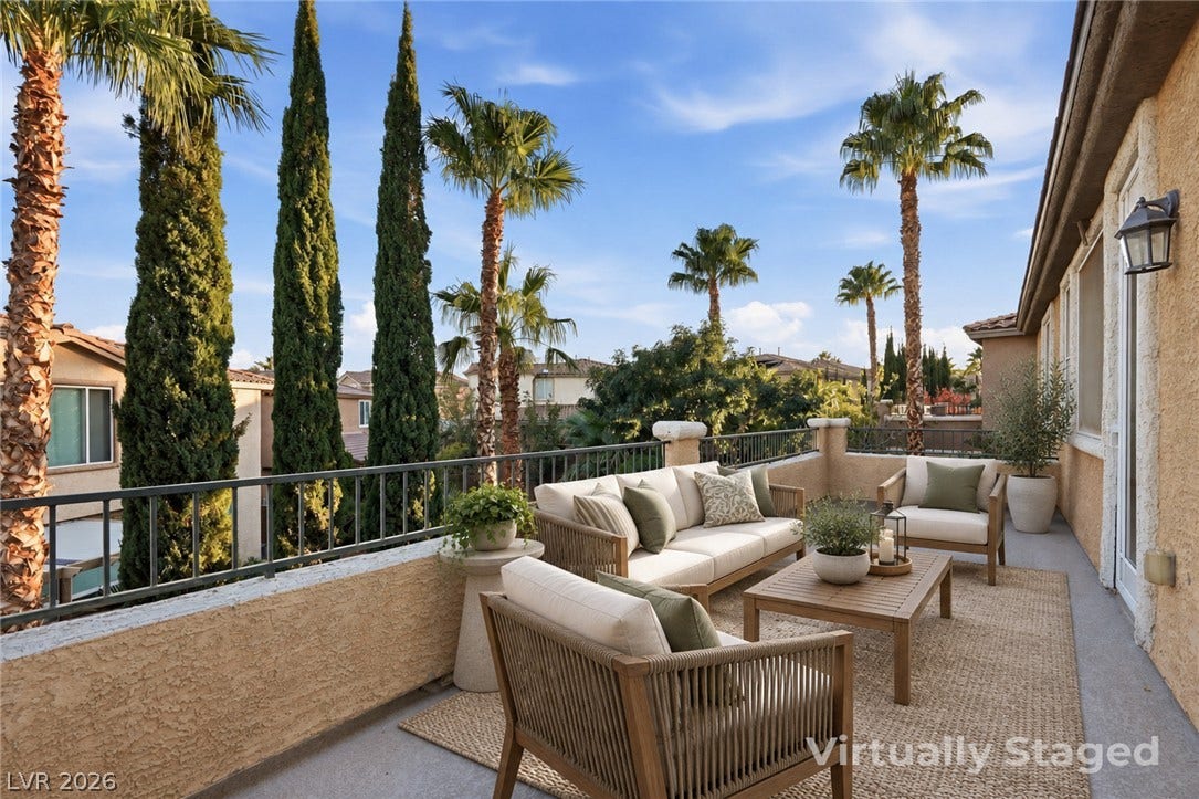 An elevated balcony provides a private retreat overlooking lush palm trees and manicured grounds.