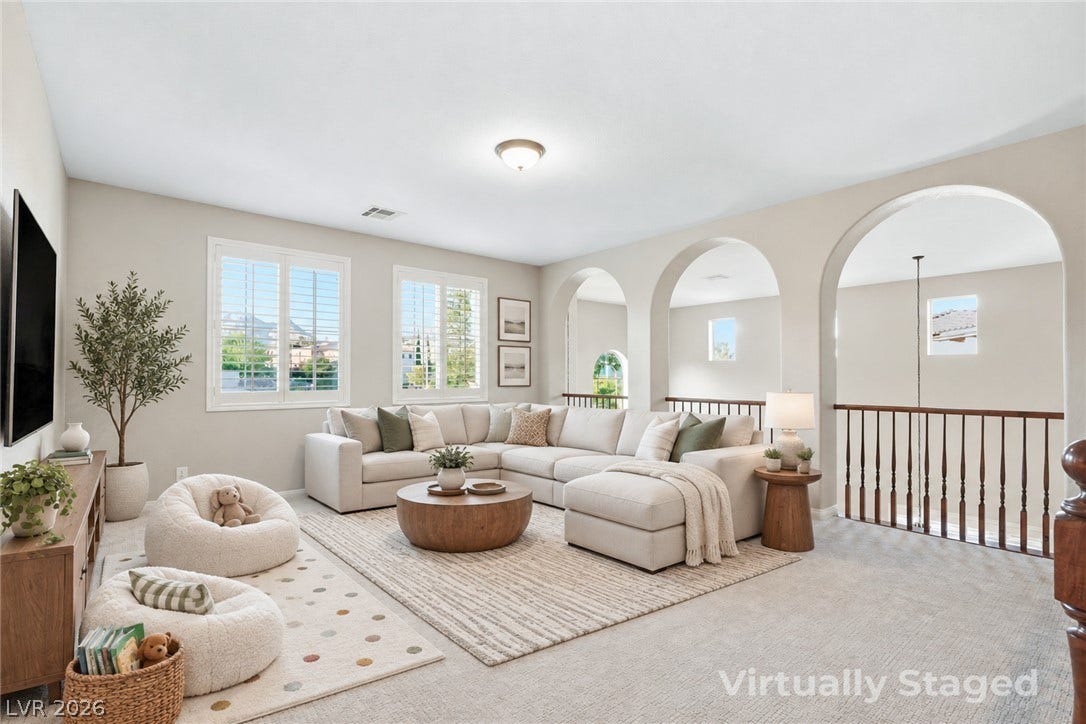 Graceful arched transitions and soft neutral carpeting define this comfortable upper-level loft space.