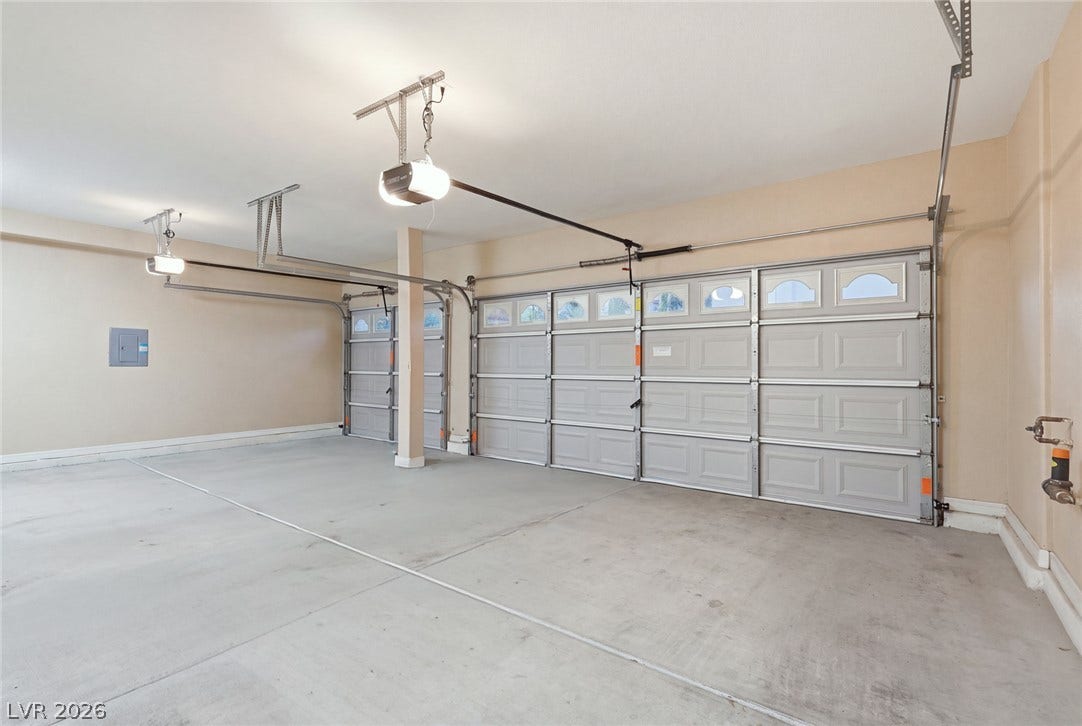 An expansive multi-vehicle garage features durable concrete flooring and automatic door openers.