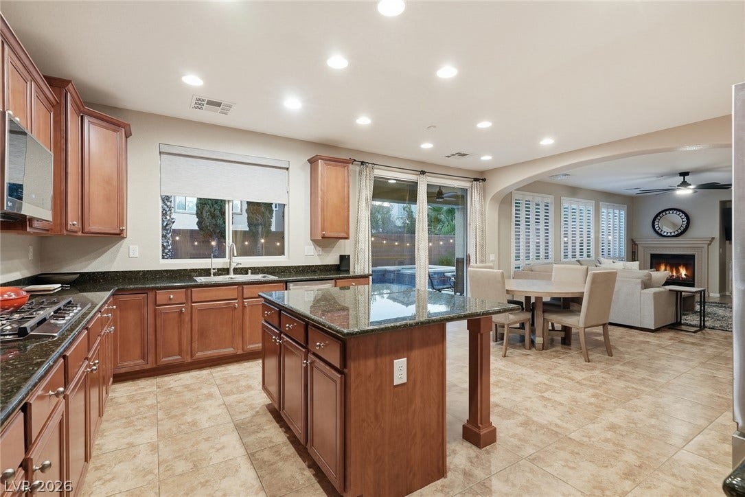 Rich wood cabinetry and a central island highlight this open kitchen layout.