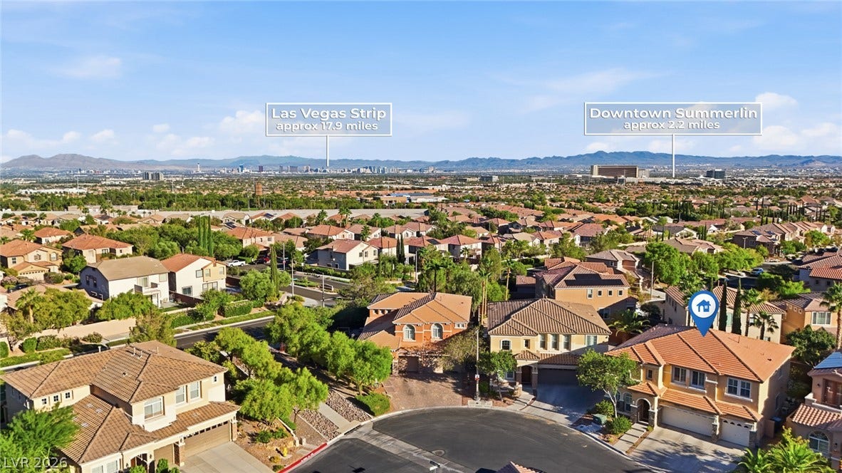 Distant mountain ranges and city skylines frame the surrounding residential neighborhood.