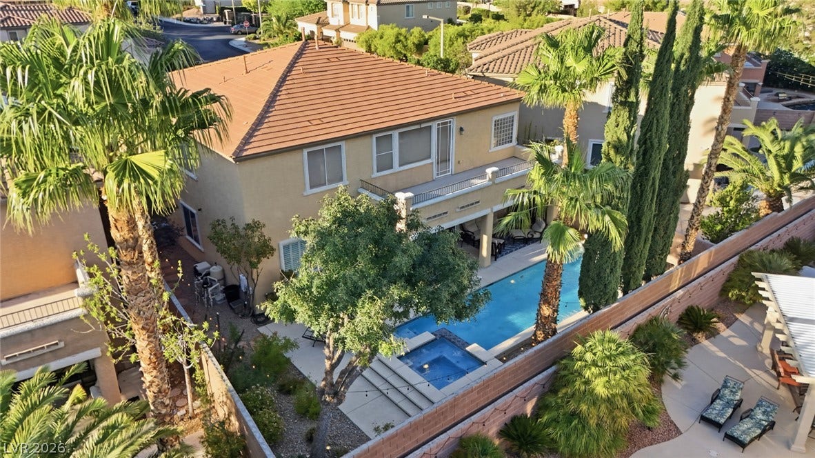 Mature palms and a sparkling pool elevate this modern two-story desert residence.