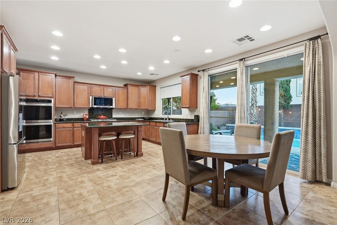 An open kitchen and dining area features tile flooring and sliding glass doors to the patio.
