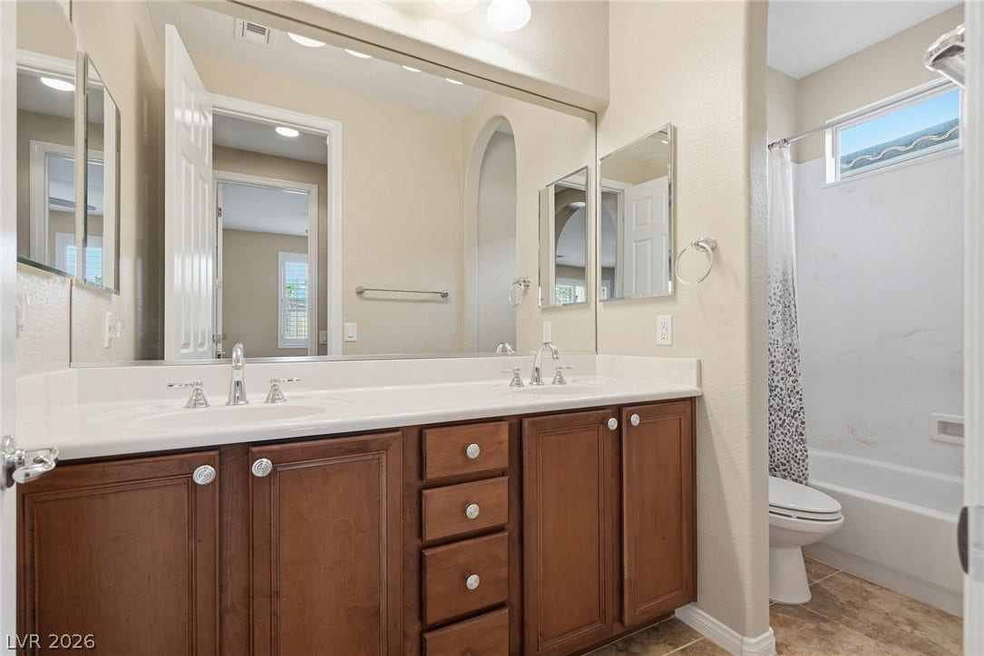 Upstairs full bath- Warm wood cabinetry and dual sinks anchor this functional bathroom layout.