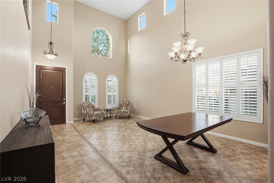 Towering ceilings and polished tile flooring elevate this formal dining space and entry hall.