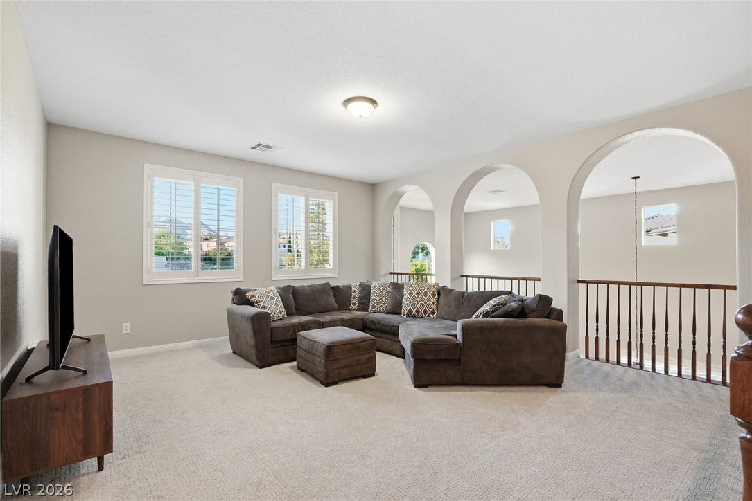 Graceful arched openings framing a loft lounge overlooking the staircase below.