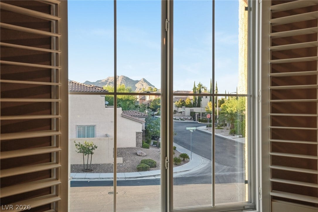 Picturesque mountain views frame the neighborhood scene through classic paned windows.
