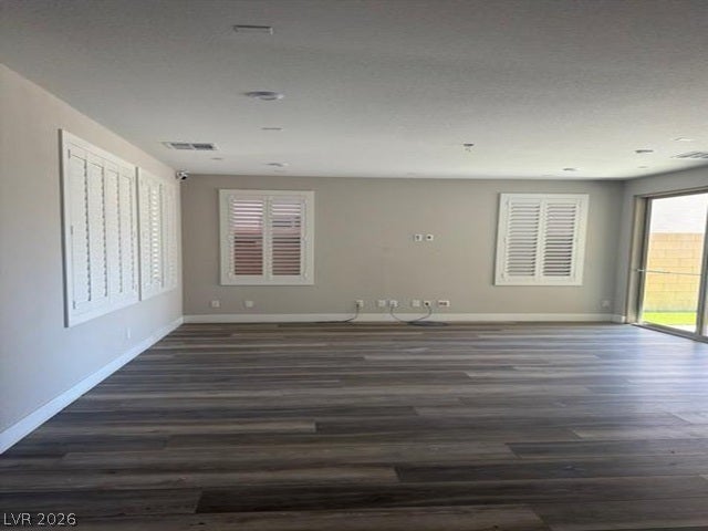 Rich wood-inspired flooring and elegant plantation shutters define this versatile living space.
