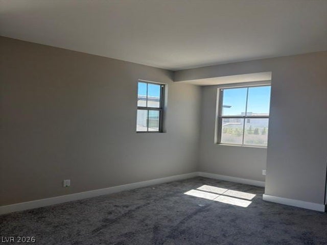 Natural light streams through multi-pane windows onto plush wall-to-wall carpeting.