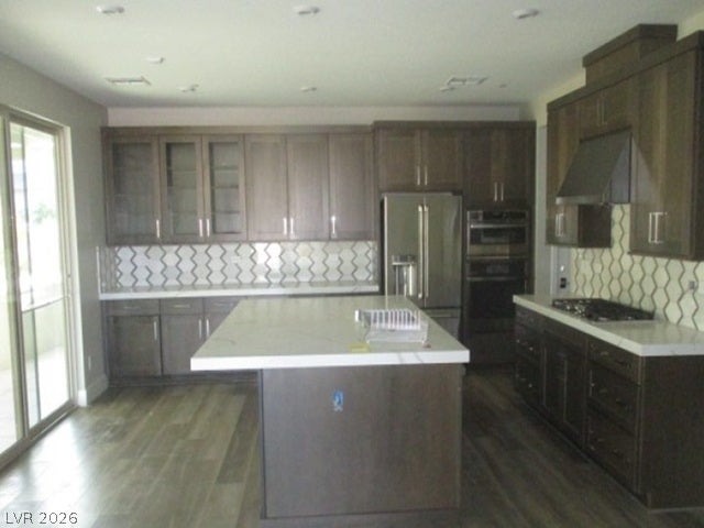 A spacious central island sits beneath recessed lighting in this modern kitchen with sliding glass doors.