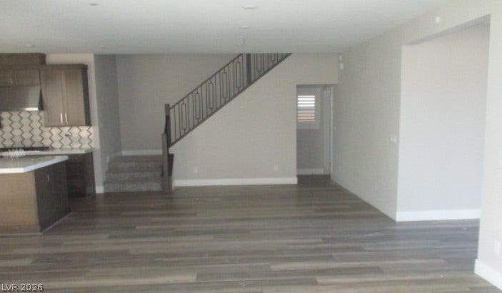 Gleaming hardwood floors and a modern staircase define this open main-level living space.