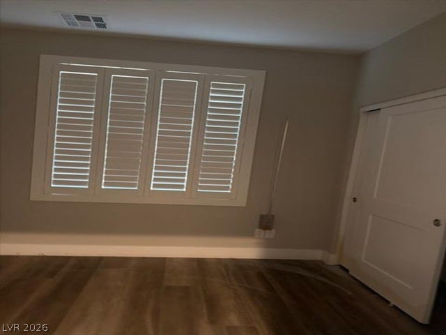 Rich wood flooring pairs beautifully with plantation shutters in this versatile room.