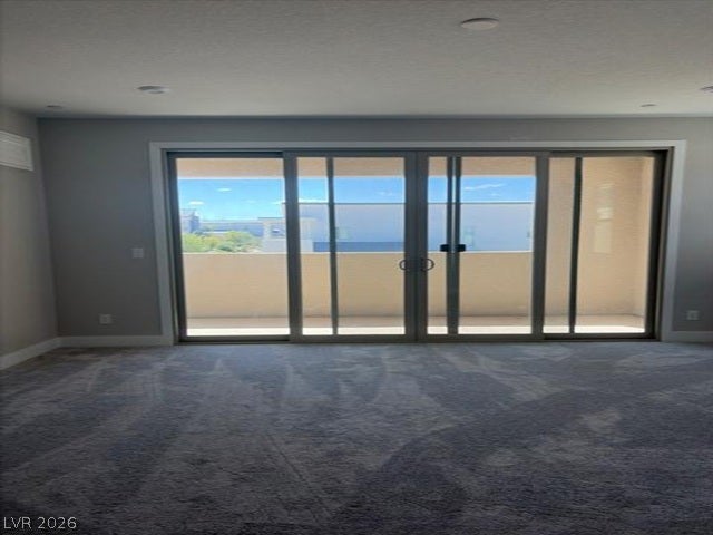 Massive sliding glass doors open from plushly carpeted interiors onto a private covered balcony.