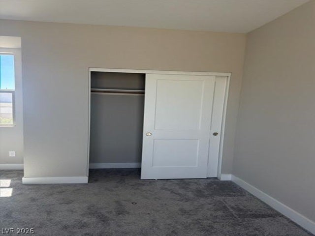 An inviting bedroom features plush carpeting and sliding closet doors.