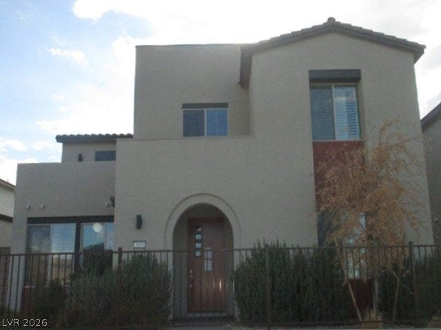 An arched entryway and stucco exterior define this contemporary two-story home.