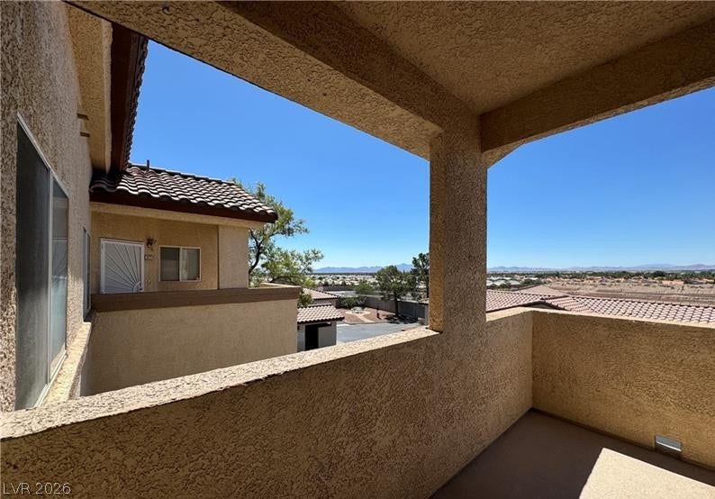 A private covered balcony frames scenic neighborhood and distant mountain views.