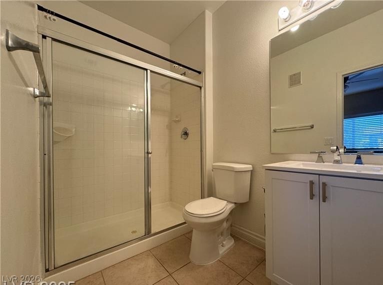 Tiled flooring and a glass-enclosed shower highlight this functional bathroom space.