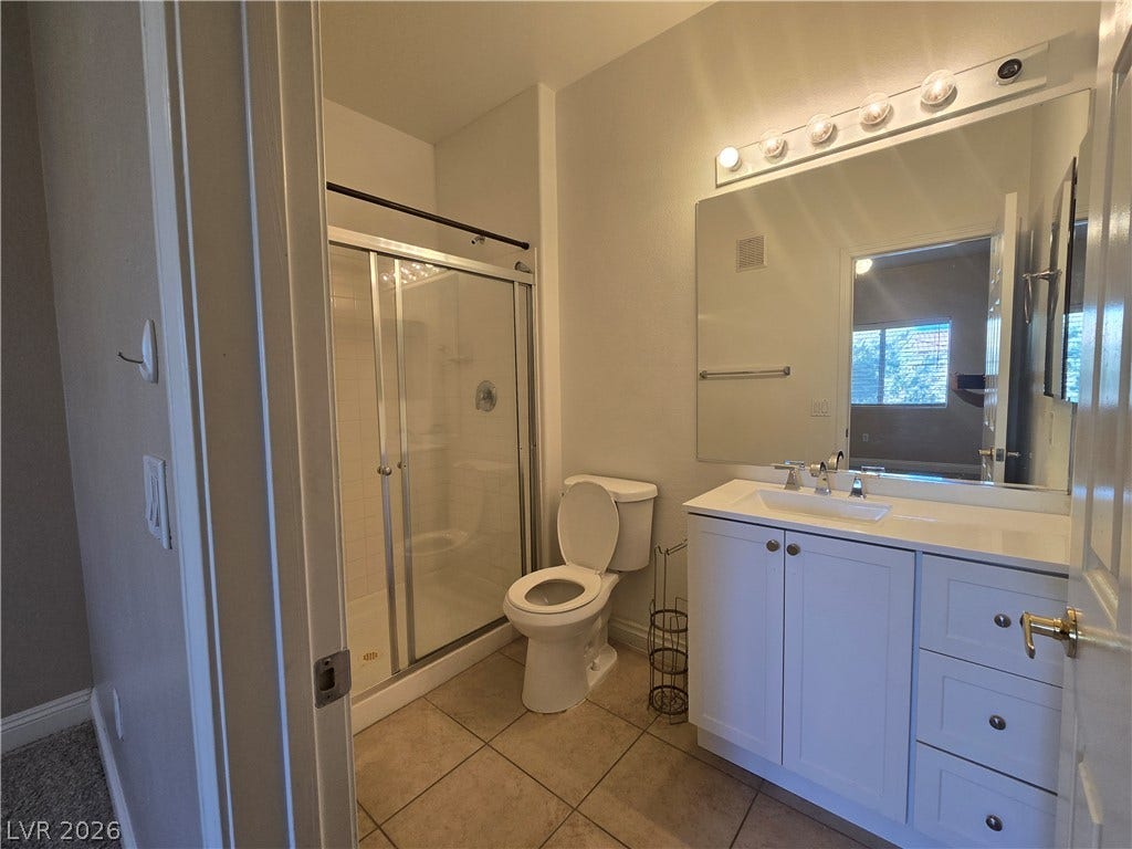 A classic vanity and tiled flooring anchor this functional bathroom space.