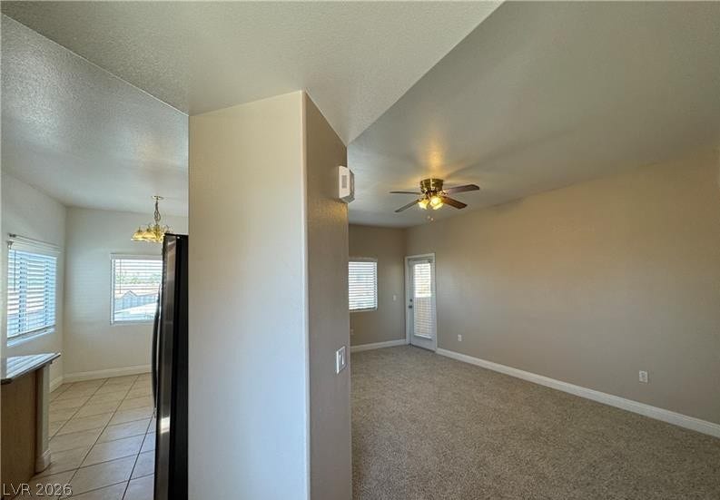 An open layout connects the tiled kitchen dining area directly to the carpeted living room.