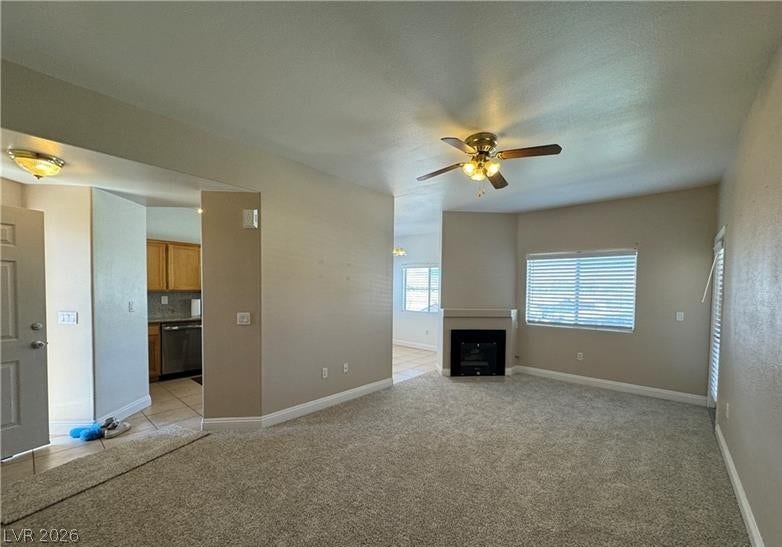 Plush carpeting and a corner fireplace define this open living area.