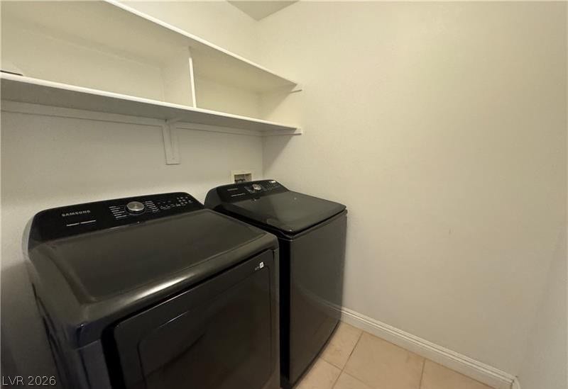 Functional laundry space features overhead shelving alongside tile flooring.