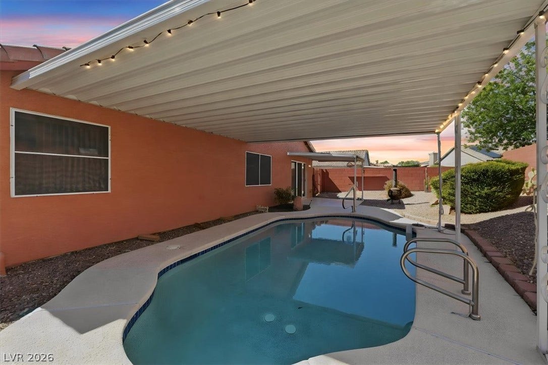 An inviting covered patio area shelters the sparkling pool in this private backyard.