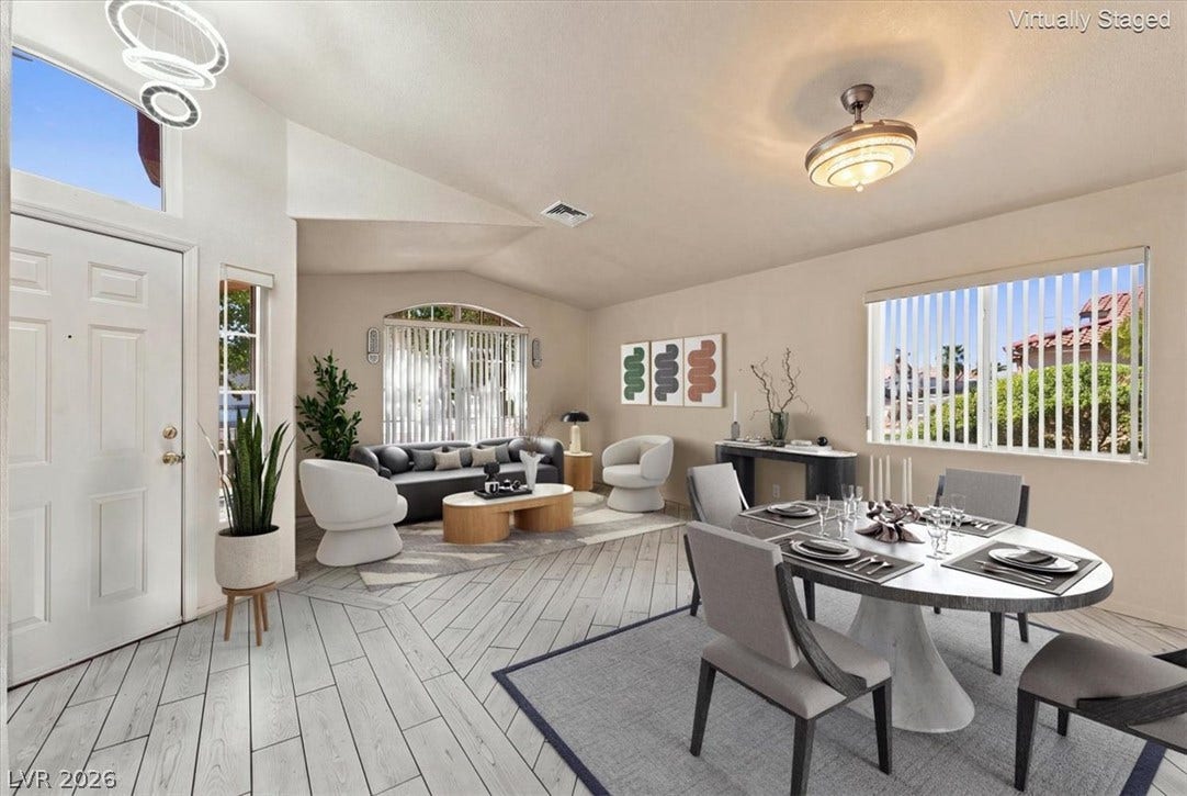 Virtually staged with Angled wood-look flooring stretches beneath vaulted ceilings in this open-concept layout.