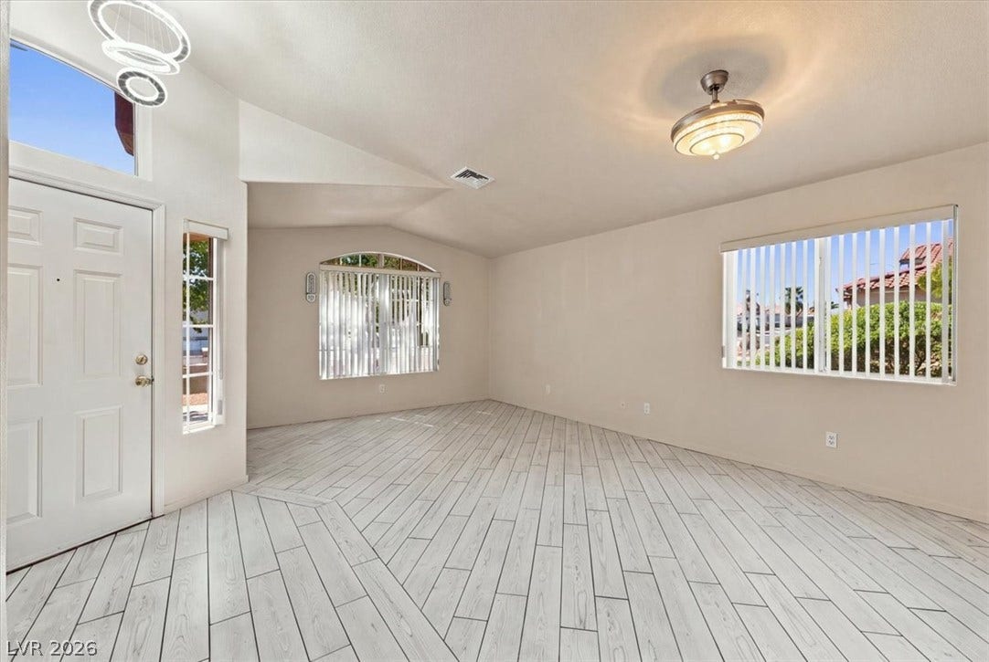 Gleaming tile floors anchor this welcoming entrance foyer with high vaulted ceilings.