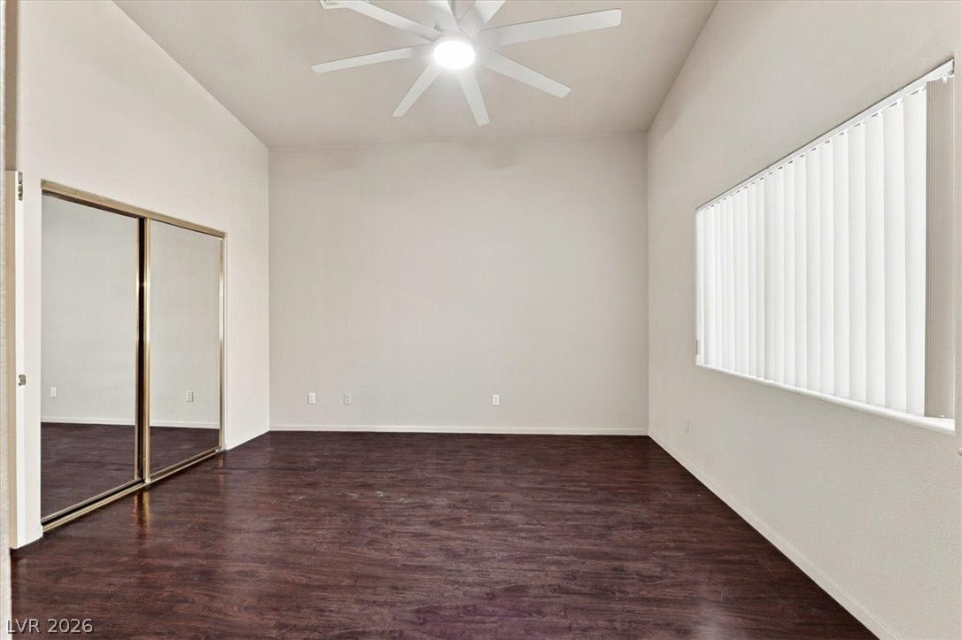 Rich wood-inspired flooring and high ceilings define this versatile bedroom space.