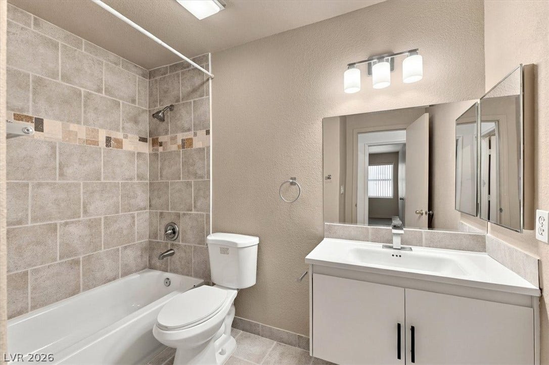 A classic tiled shower surround highlights this thoughtfully configured full bathroom space.