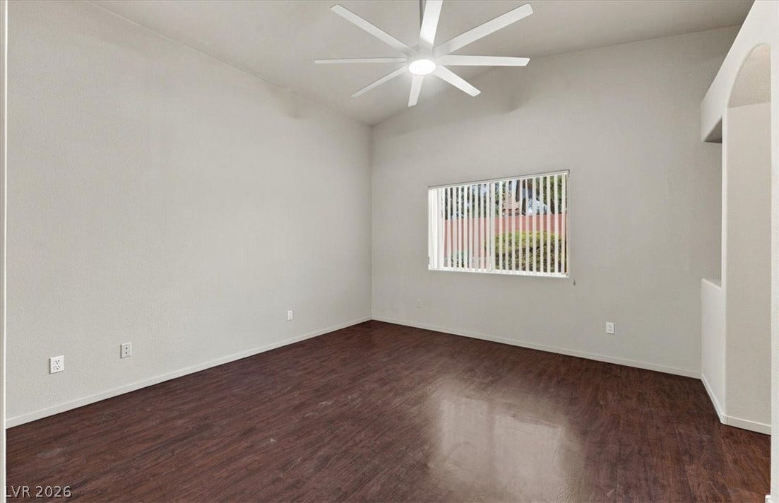 Gleaming wood floors anchor this versatile room beneath a vaulted ceiling.