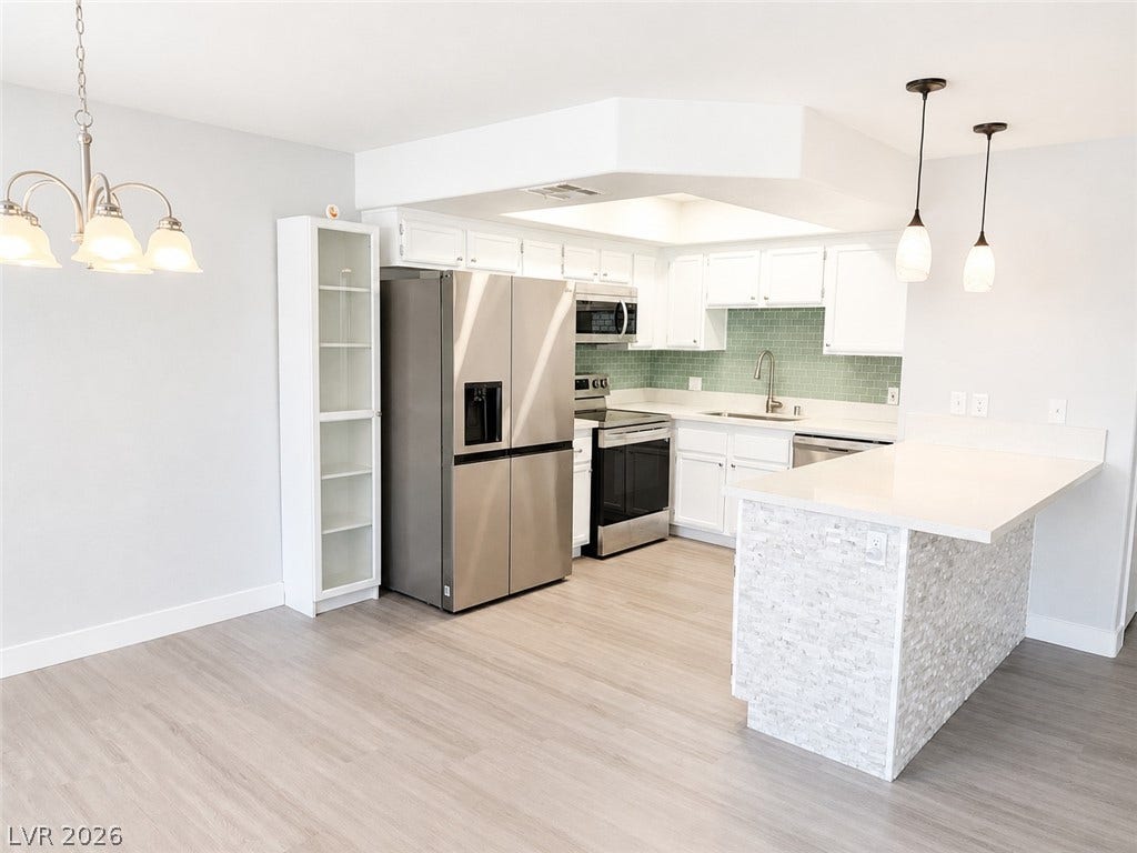Gleaming wood floors anchor this open kitchen complete with stone countertops and built-in cabinetry.