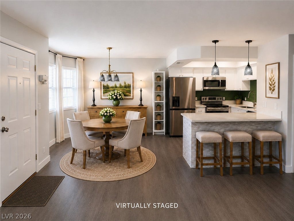 Gleaming hardwood floors unite the open-concept dining area and fully equipped kitchen space.