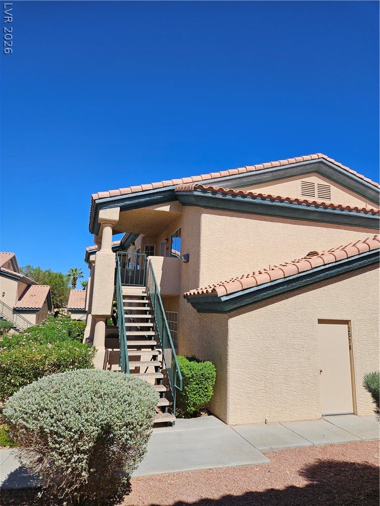 Stucco exterior elements and concrete pathways create a classic desert architectural style.