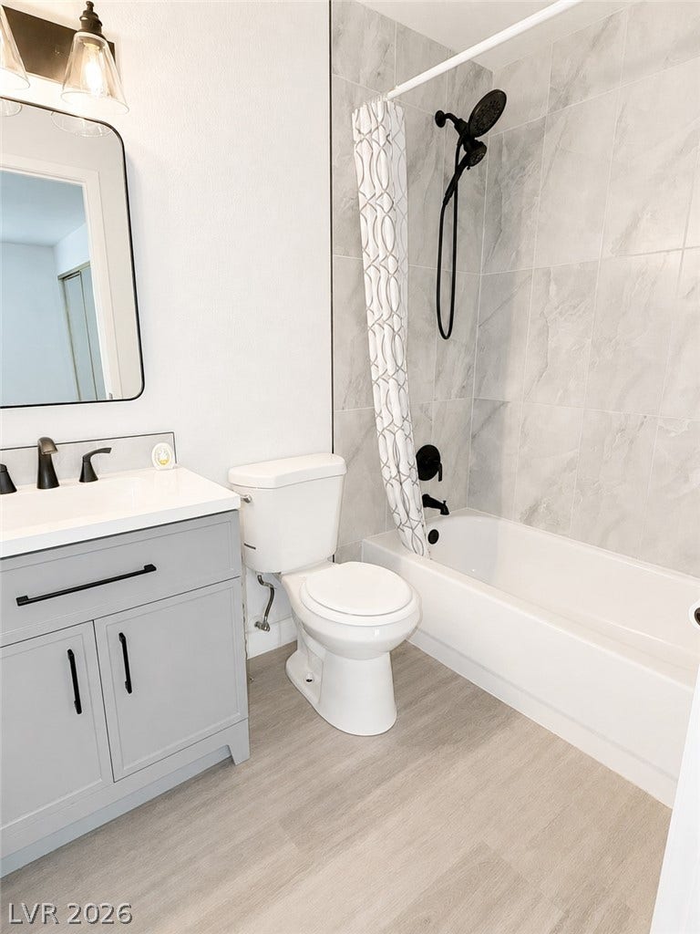 Modern finishes complete this bathroom featuring a tiled tub surround and updated vanity.