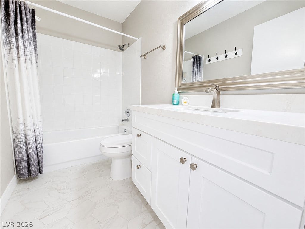 Crisp tiled flooring and an expansive vanity create a clean, modern aesthetic.