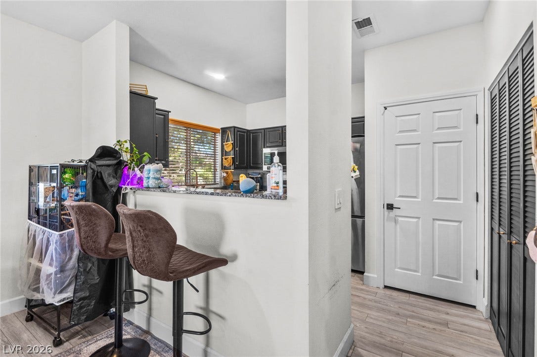 5250 S Rainbow Boulevard, #2033, Las Vegas, NV 89118 A breakfast bar opens to the kitchen from this bright interior space.
