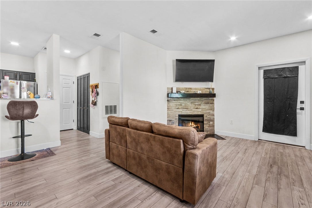 5250 S Rainbow Boulevard, #2033, Las Vegas, NV 89118 An inviting stone fireplace anchors the open-concept living area with durable wood-look flooring.