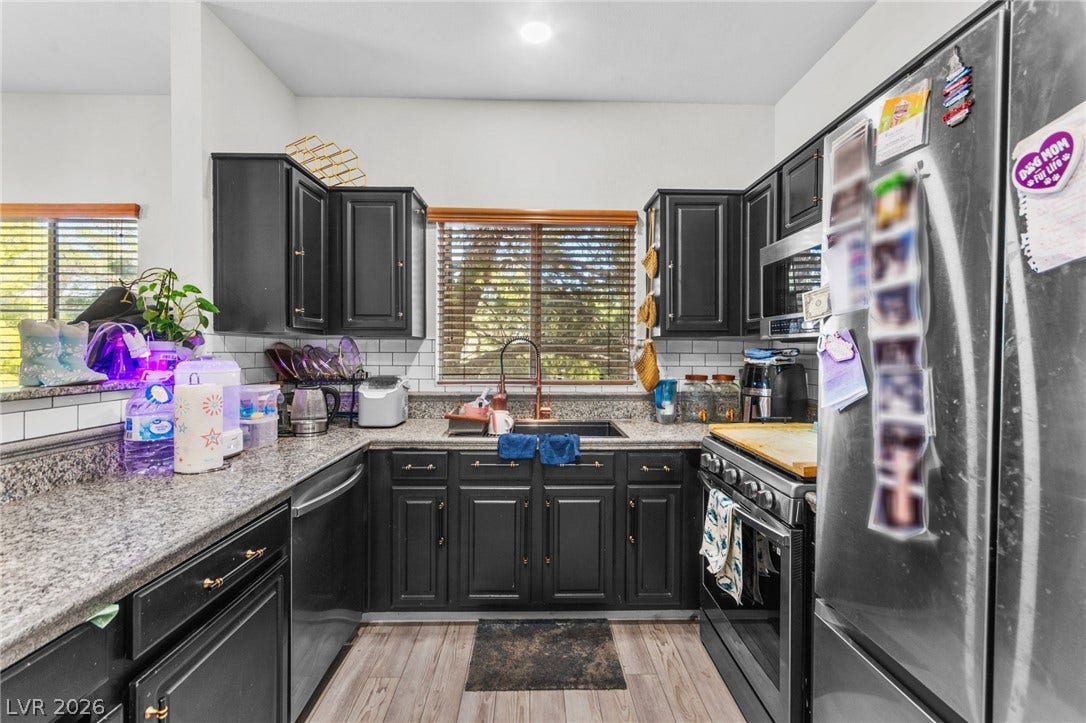 5250 S Rainbow Boulevard, #2033, Las Vegas, NV 89118 Dark cabinetry beautifully contrasts with granite countertops and a classic subway tile backsplash.