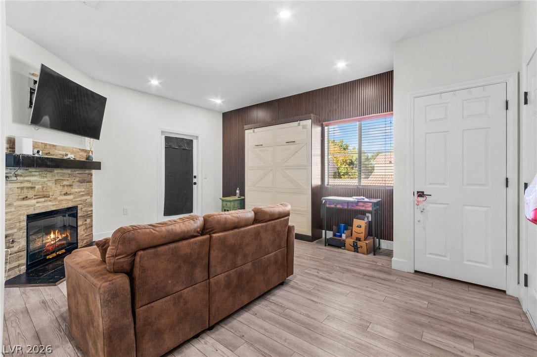 5250 S Rainbow Boulevard, #2033, Las Vegas, NV 89118 Recessed lighting and a stone-clad fireplace enhance this versatile living space with wood-look flooring.