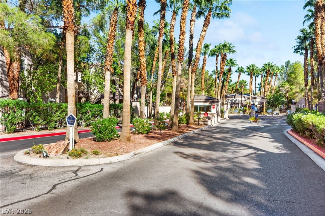 5250 S Rainbow Boulevard, #2033, Las Vegas, NV 89118 Towering palm trees frame the paved entry drive leading into this gated neighborhood.
